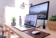 MacBook Pro on table beside white iMac and Magic Mouse