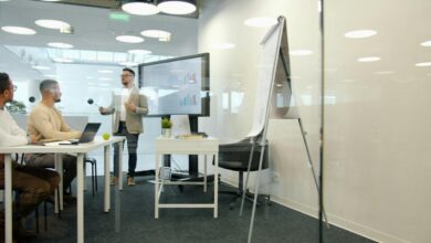 Man presenting to colleagues in a modern office meeting.