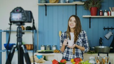 Woman filming herself cooking in a kitchen.